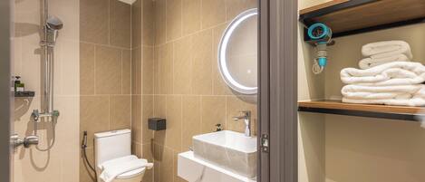 Un baño moderno con inodoro, lavamanos y ducha.