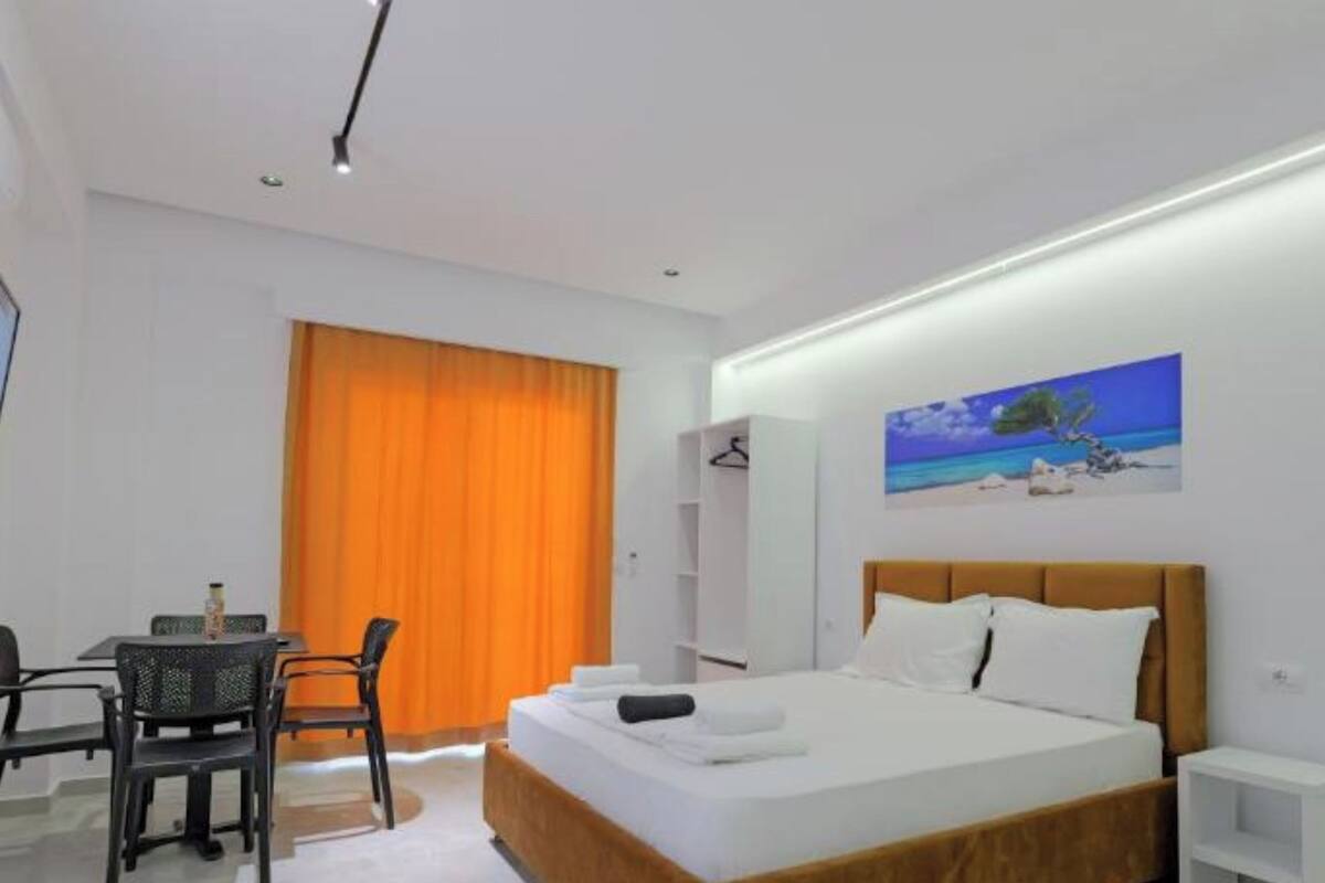 A modern hotel room with a large bed, a desk, and a painting on the wall.