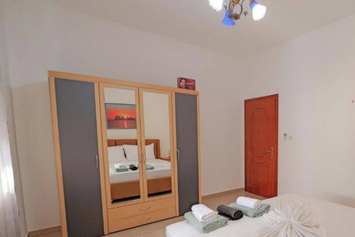 A bedroom with a bed, a wardrobe, and a door.