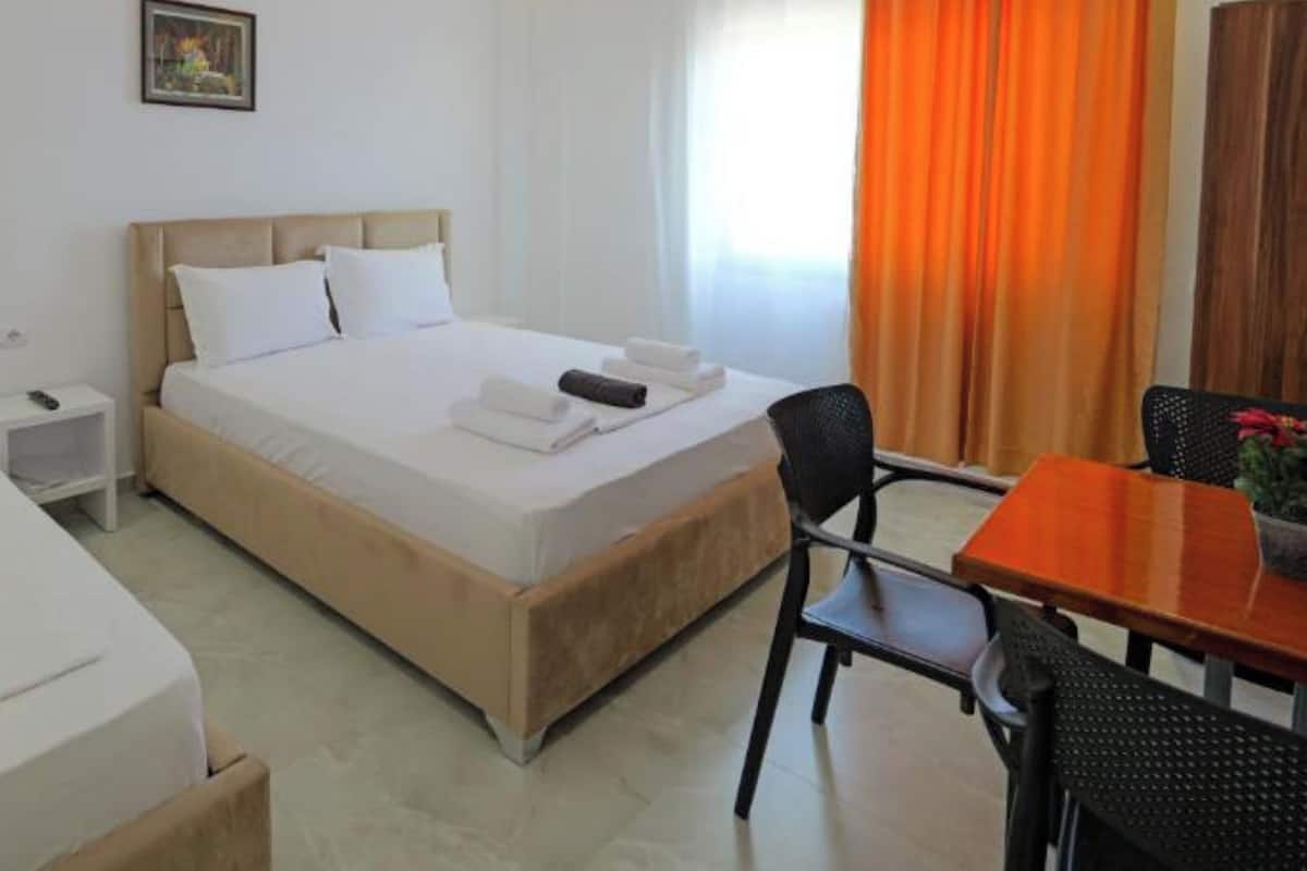 A hotel room with a bed, a desk, and a chair.