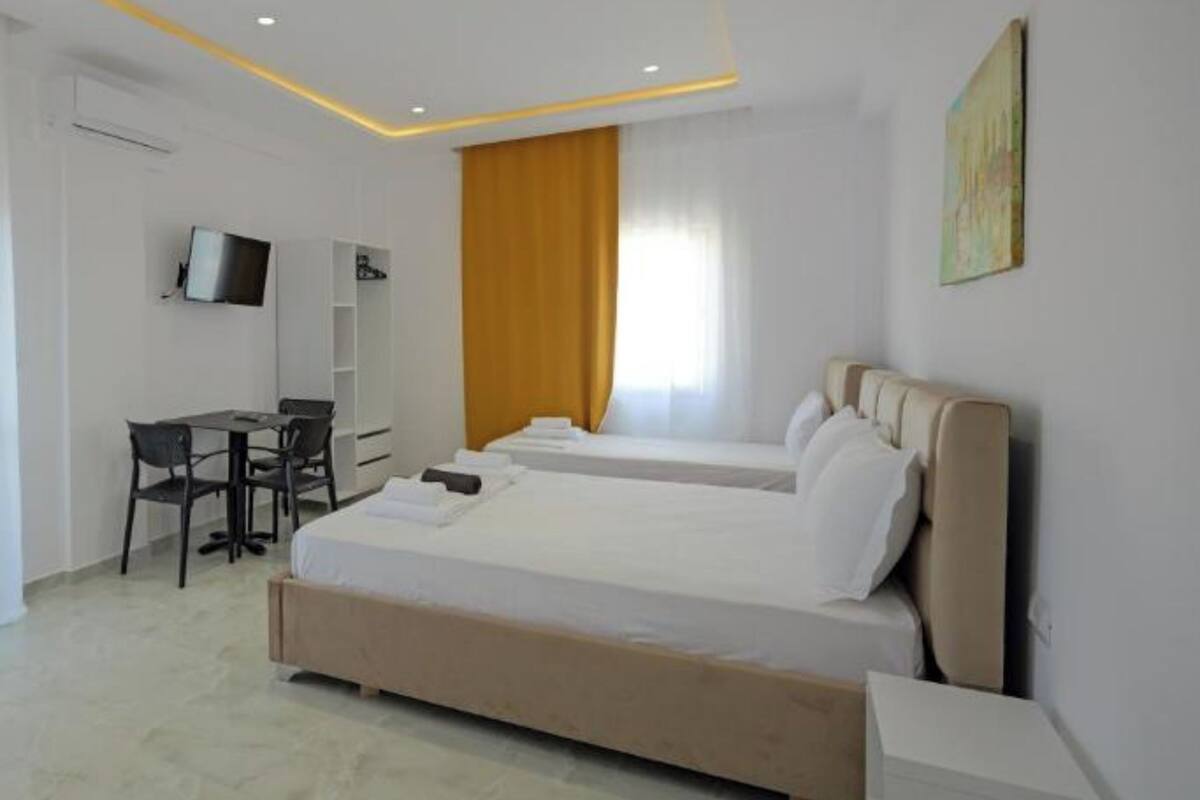 A modern hotel room with a large bed, a desk, and a chair.