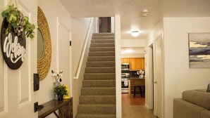 A staircase leading to a kitchen with wooden cabinets and a dining area. - Azul Oasis - No house guest without prior approval from host. (Albuquerque)