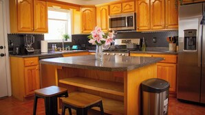 A kitchen with wooden cabinets, a granite countertop, a stainless steel refrigerator, and a sink. - Azul Oasis - No house guest without prior approval from host. (Albuquerque)