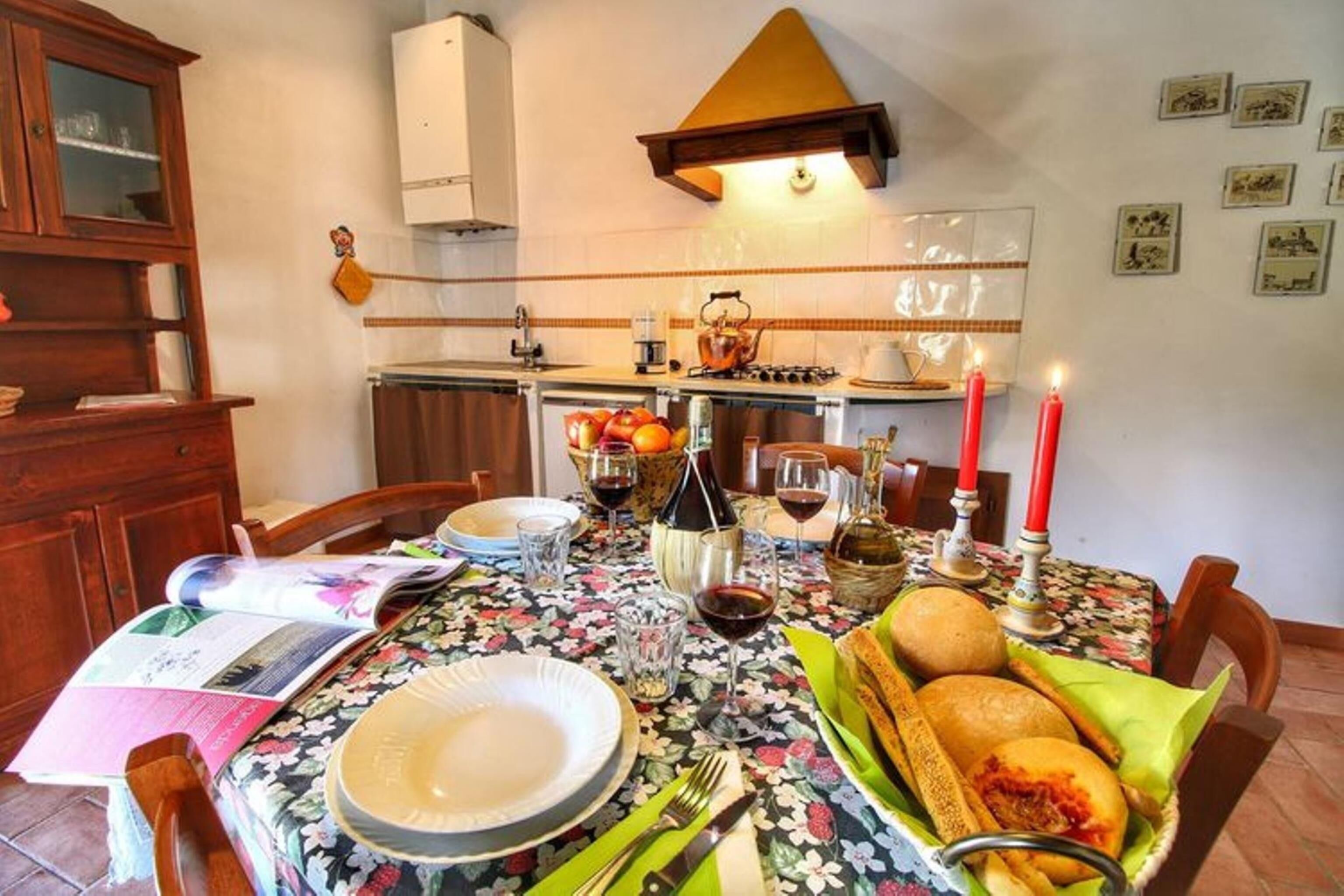 A dining table set with plates, glasses, and a basket of bread.