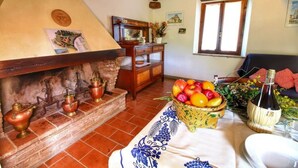 Une pièce rustique avec une cheminée, des meubles en bois et un panier de fruits.