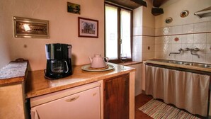 Une cuisine équipée d’une machine à café, d’une bouilloire et d’un évier.