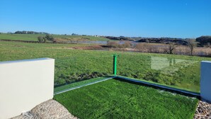 A view from a balcony with a green lawn and a clear blue sky. - Immaculate 2-bed Cottage in Tuam (Polladooey)