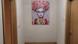 A hallway with wooden doors, a modern ceiling light, and a painting on the wall. - Immaculate 2-bed Cottage in Tuam (Polladooey)