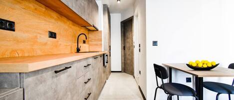 Een koelkast, een microgolfoven, een kookplaat, een eettafel