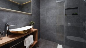 Ein modernes Badezimmer mit einem großzügigen Waschtischbecken, einem Spiegel und einer Duschkabine.