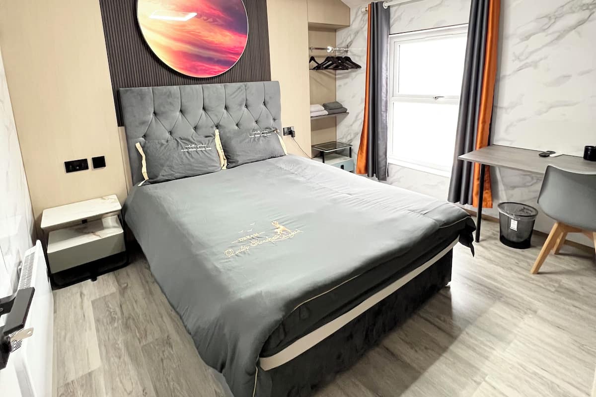 Une chambre moderne avec un grand lit, un bureau et une armoire.