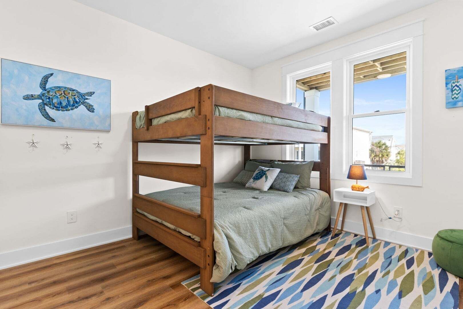A bunk bed room with a window, a star decoration, and a painting of a turtle.