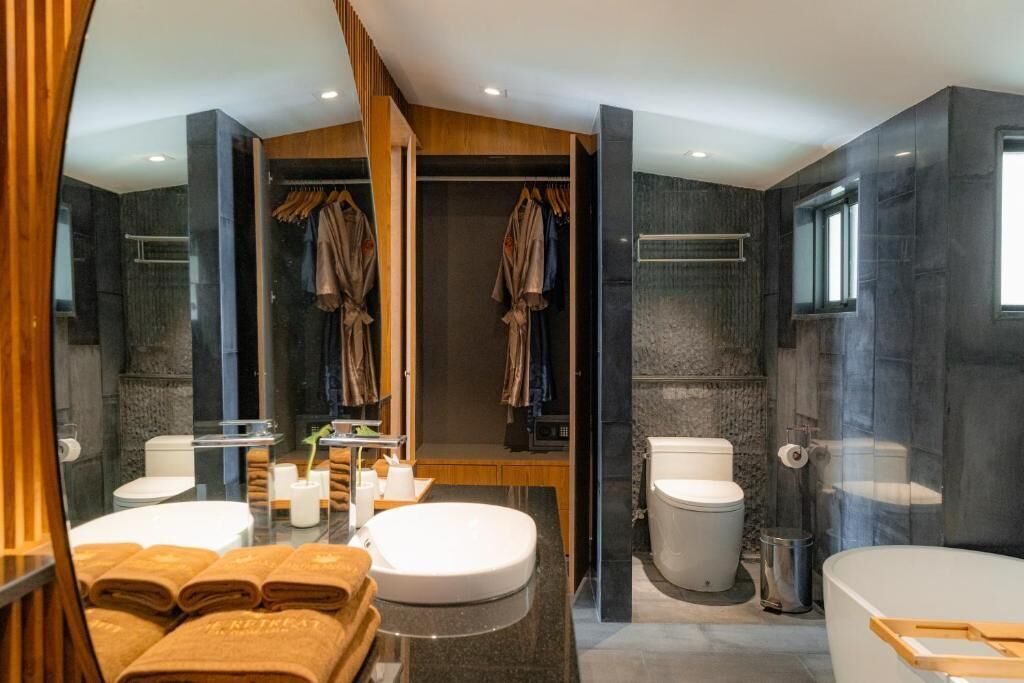 Een moderne badkamer met een douchecabine van glas, een grote spiegel, een wastafelmeubel met een wastafel en een bad.