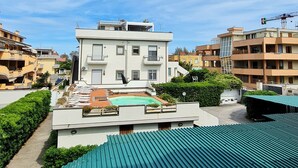 Un immeuble d’habitation doté d’un toit plat, d’un petit jardin et surplombant un ciel dégagé.