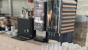 A buffet setup with coffee machines, plates, cups, and bread. - Celeste Hotel (Fethiye)