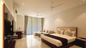 A modern hotel room with a large bed, a desk, a chair, and a television. - Hotel Corbett Paradise Kotdwar (Lansdowne)