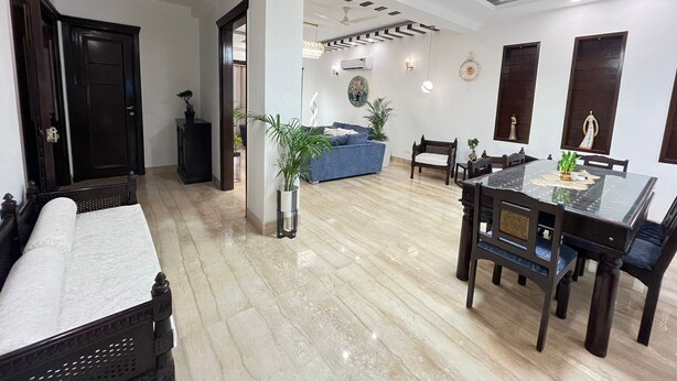 Un salón amplio con una mesa de comedor, sofás y una araña.