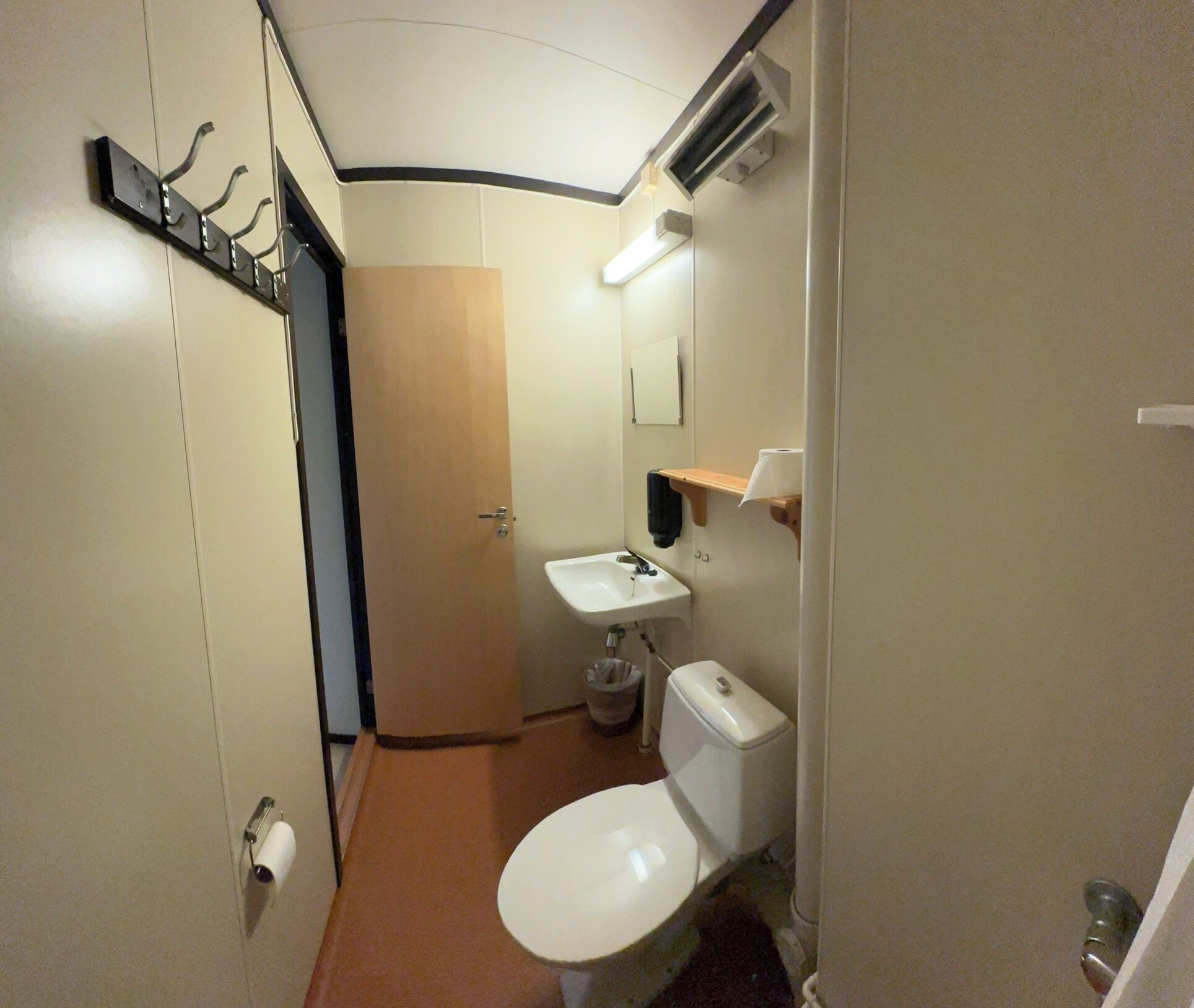 Une petite salle de bain comprenant des toilettes, un lavabo et un miroir.