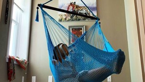 A blue hammock chair suspended from the ceiling in a room with beige walls, a window, and a door. - MASSiVE Bohemian Oasis in Philly 5 BdrmSleeps 12 (Philadelphia)