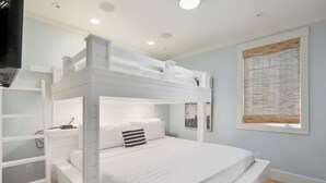 A bunk bed room with white bedding, a wooden floor, and a window with blinds. - 7 BR 8 BA Private Pool Singleton Beach Sleeps 24 Bikes & Beach Gear included (Hilton Head Island)