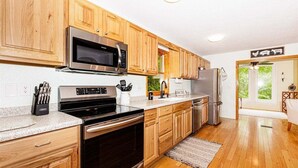 Une cuisine moderne avec des meubles en bois, des appareils en acier inoxydable et un plan de travail en granit.