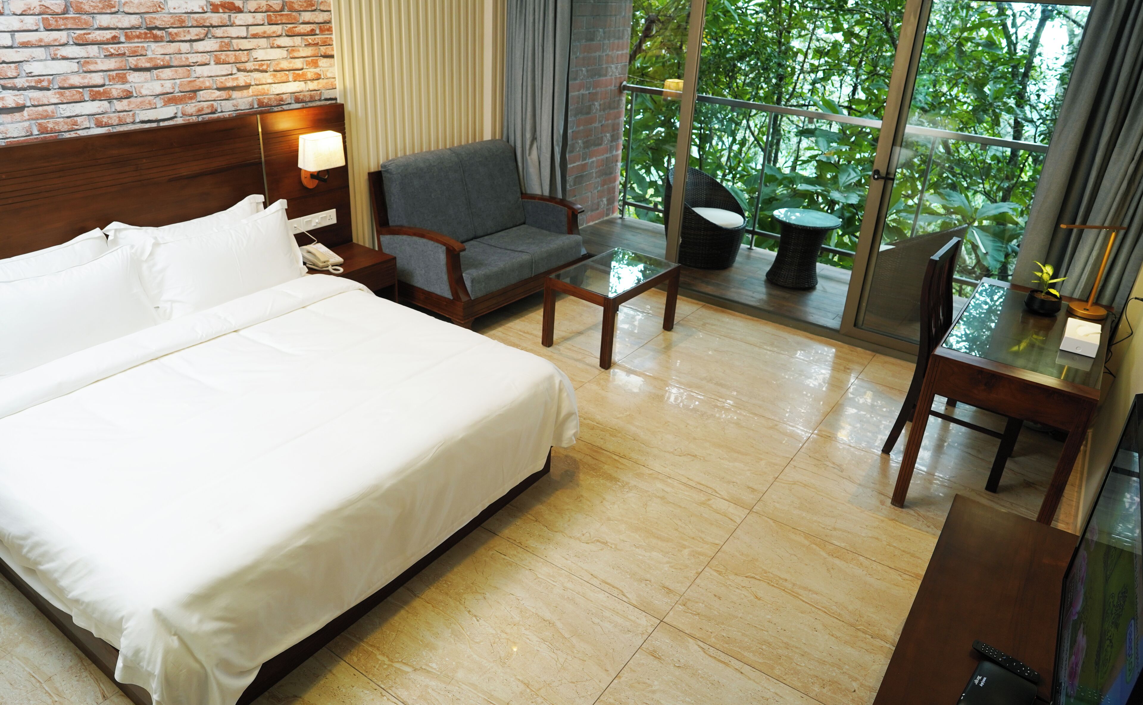 Een hotelkamer met een bed, een stoel, een klein tafeltje en een televisie.