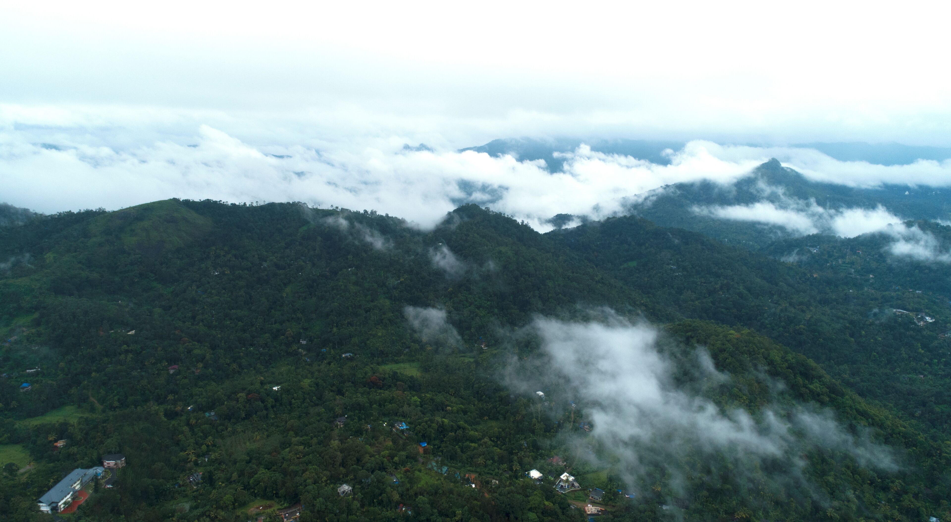 A mountainous landscape with dense forests and scattered buildings.