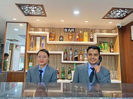 Una zona de bar con estanterías llenas de botellas de licores y vasos.