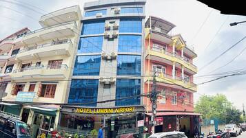 A multi-story building with a hotel named 'Hotel Lumbini Airport' on the ground floor.