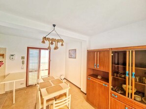 Enjoy meals in the dining area with a table and chairs, complemented by a stylish light fixture.