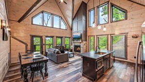 Una cabaña espaciosa con un amplio comedor, una sala de estar acogedora y una cocina con chimenea de piedra.