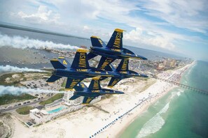 A group of U.S. Navy Blue Angels aircraft flying over a coastal area with a beach and a bridge. - Gulf Breeze Oasis with Private Pool (Gulf Breeze)