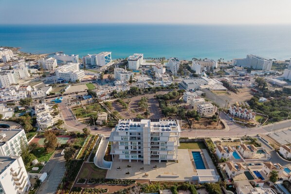 A modern hotel complex with multiple buildings, a central courtyard, and a swimming pool.