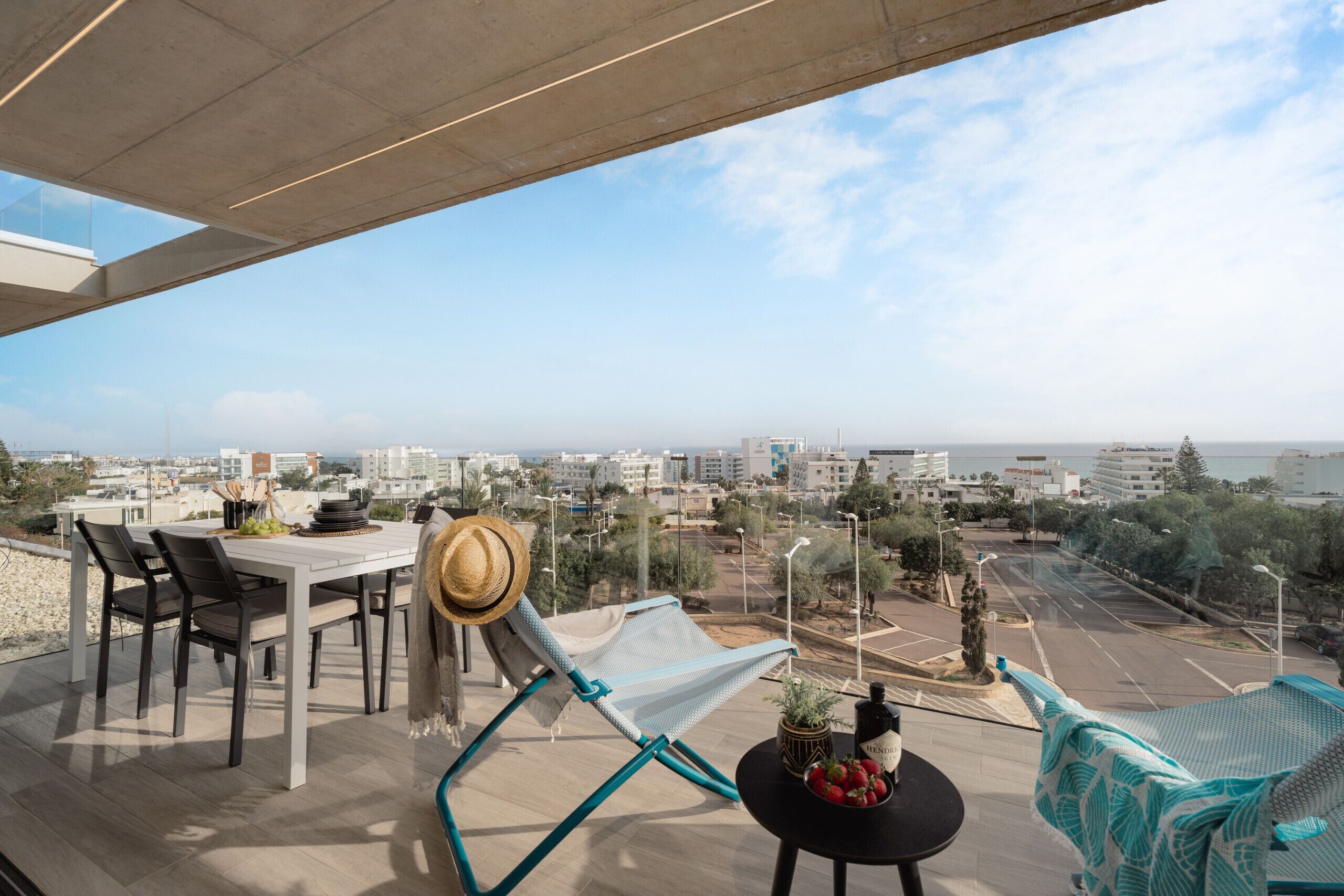 Un balcón con mesa, sillas y vistas de la ciudad.