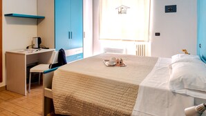 Un dormitorio con cama, escritorio, silla y armario.