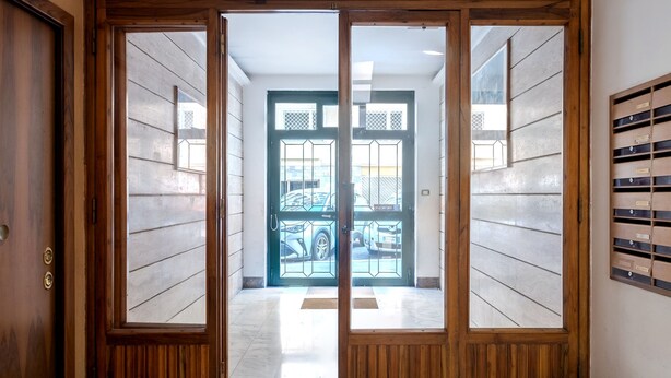 Un pasillo con una puerta de madera que da a un garaje.