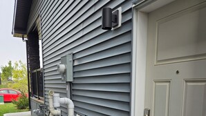 A residential exterior with a garage door, exterior pipes, and a red car parked in the driveway. - Parkside Basement Suite/Netflix, Amazon Prime & Disney  (Edmonton)