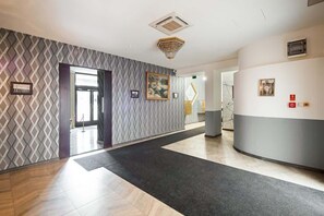 Welcome to our lobby, featuring a reception desk, patterned wall, and artwork, creating a welcoming space for guests.