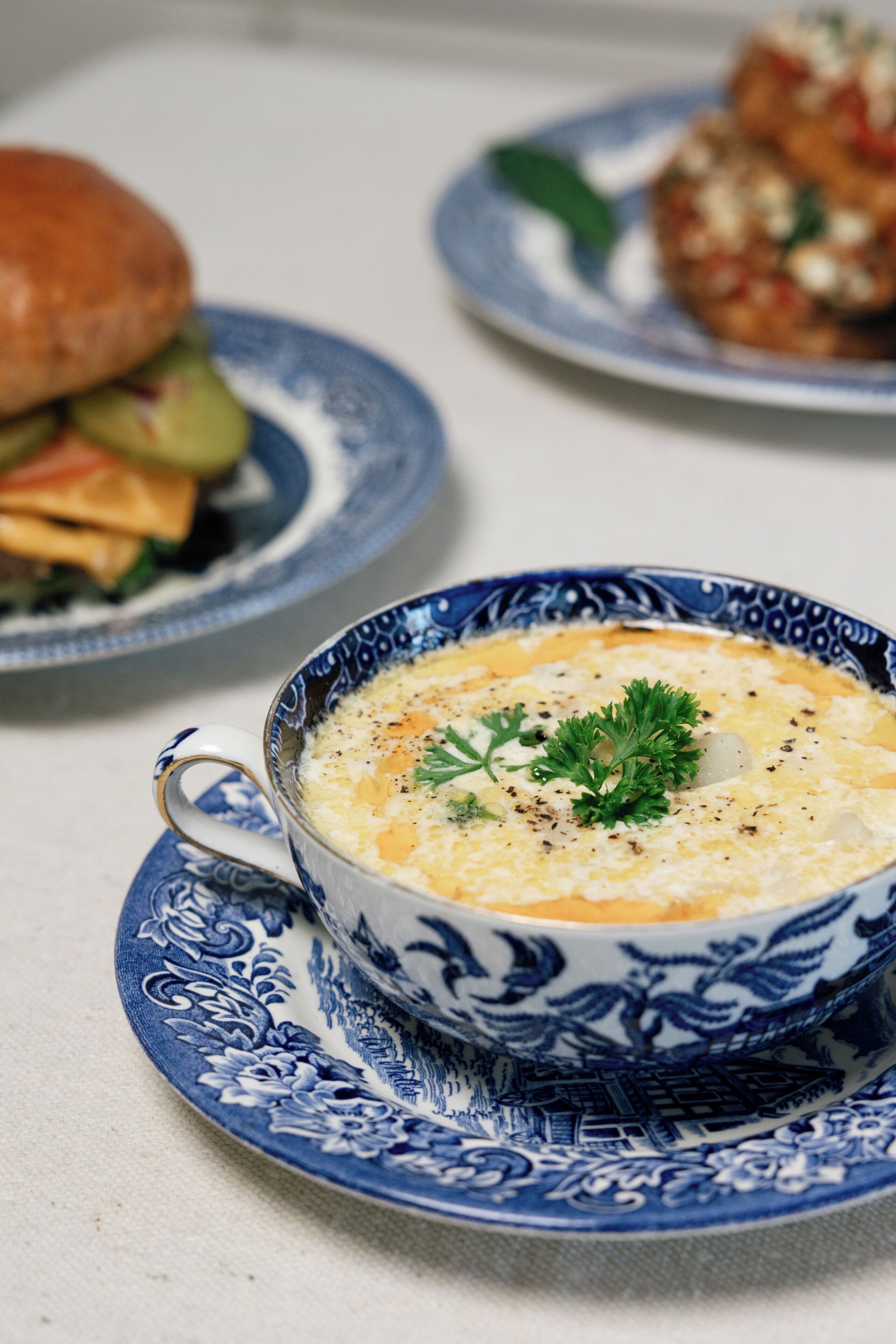 A bowl of soup on a blue and white patterned plate.