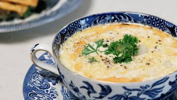 A bowl of soup on a blue and white patterned plate.