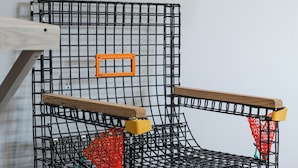 A room with a bed, a wooden headboard, and a black metal cage structure. - Homeport Suites & Residences (Lords Cove)