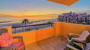 Ein Balkon mit Blick auf einen Strand und ein Hotelgebäude.