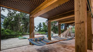 A hammock under a wooden pergola with a view of a beach and palm trees. - Private Beach Access Steps Away,  Pool, Outdoor Bar, 2 Golf Carts, 360 Views. (Captiva)