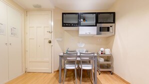 A compact kitchen with a dining table and chairs, a microwave, and a small cabinet. - Exclusive & Cozy Apartment in the Center of Soria (Soria)