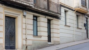 A building with a beige facade, a black wrought iron gate, and a balcony with a black railing. - Exclusive & Cozy Apartment in the Center of Soria (Soria)