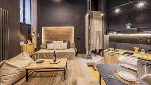A modern, compact hotel room with a bed, a small dining area, a kitchenette, and a large window. - Design and Elegance in the Heart of Madrid (Madrid)