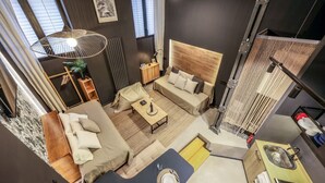 A modern living room with a sofa, coffee table, and a dining area. There is a kitchen with a sink and a dining table. - Design and Elegance in the Heart of Madrid (Madrid)