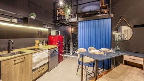 A compact kitchen with a red refrigerator, wooden cabinets, and a blue partition. - Design and Elegance in the Heart of Madrid (Madrid)