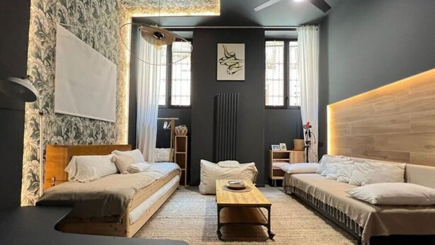 A modern bedroom with a bed, two sofas, a coffee table, and a large window. - Design and Elegance in the Heart of Madrid (Madrid)
