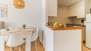 Une cuisine moderne avec des armoires blanches, un plan de travail en bois et un luminaire suspendu.